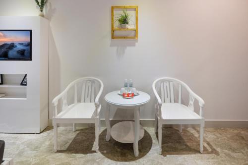 two white chairs and a white table and a table and chairs at Casa Maya Resort in ThÃ´n Báº£o An