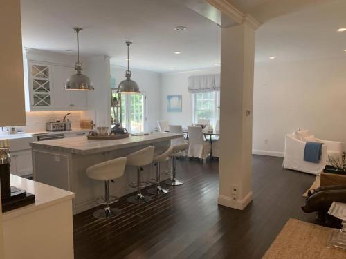 a kitchen and living room with a counter and chairs at Villa Zainip - Luxury with pool in Sag Harbor