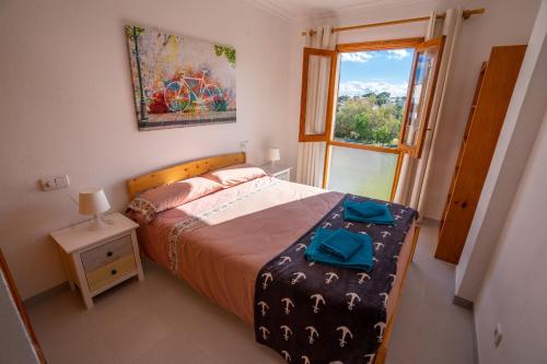 um quarto com uma cama e uma janela em LAS COLUMNAS em Port de Pollensa