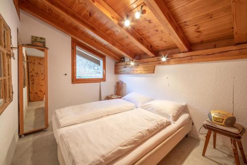 - une chambre avec un grand lit dans une pièce dotée de plafonds en bois dans l'établissement Casa Ansiel, à Falera