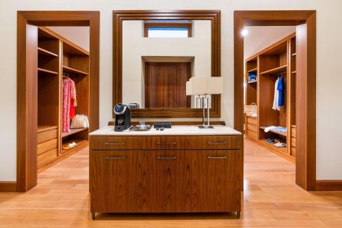 a walk in closet with wooden cabinets and a lamp at Il San Corrado di Noto in Noto
