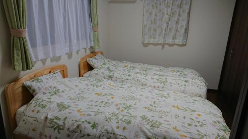 - une chambre avec un lit et une couette blanche dans l'établissement 桃山ゲストハウス おかだ, à Kyoto