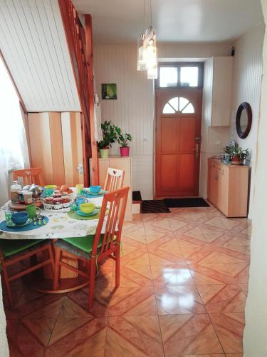ein Esszimmer mit einem Tisch, Stühlen und einer roten Tür in der Unterkunft Chambres d'Hôtes Vadiera in Autun