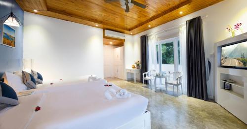 a living room with a white couch and a tv at Casa Maya Resort in ThÃ´n Báº£o An