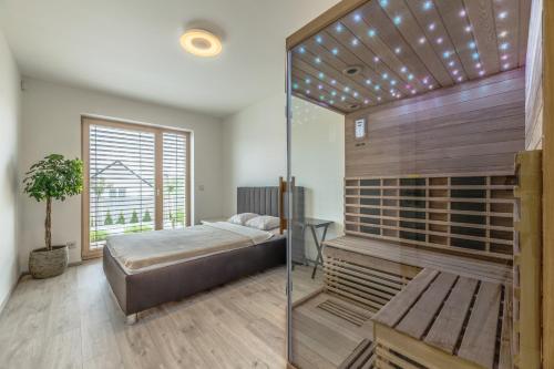 a bedroom with a bed and a glass wall at Luxury Spa Villa in Králŭv Dvŭr