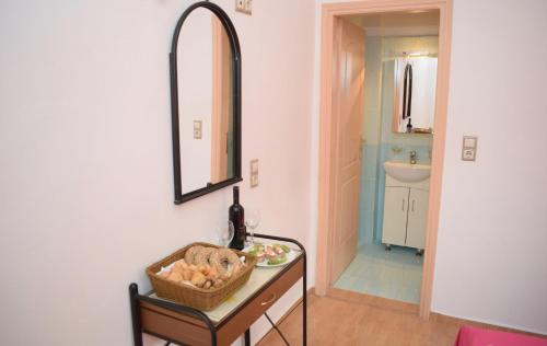 ein Bad mit einem Tisch, einem Spiegel und einem Waschbecken in der Unterkunft Niki's House in Asómatoi