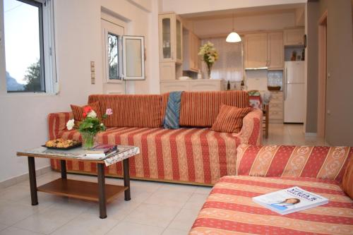 ein Wohnzimmer mit einem Sofa und einem Tisch in der Unterkunft Niki's House in Asómatoi