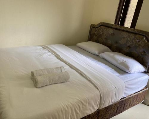 een bed met twee kussens en een handdoek erop bij Jatiwinangun Homestay near GOR Satria Purwoketo Mitra RedDoorz in Purwokerto