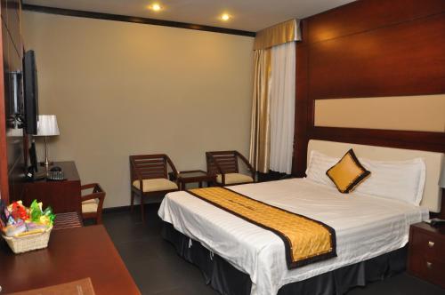 a hotel room with a bed and a table and chairs at Monte Carlo Hotel Hai Phong in Hai Phong