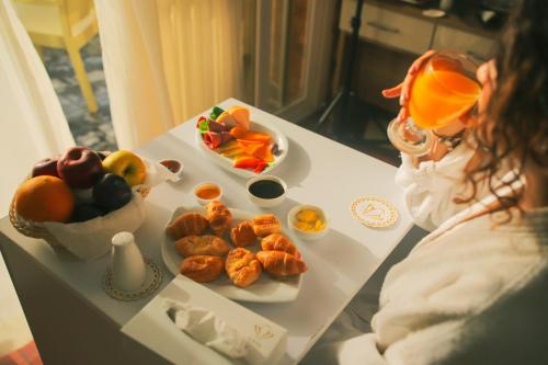 una mujer sentada en una mesa con un plato de comida en Jewel Maadi Cabins and Club, en El Cairo