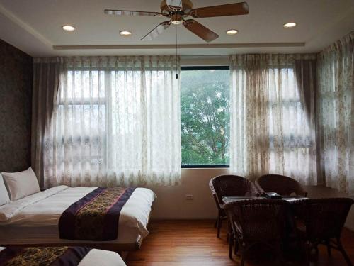 a bedroom with a bed and a table and a window at Jimei Homestay in Jian