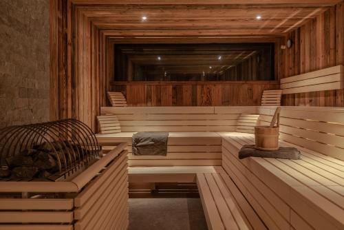 a sauna with wooden walls and benches in a room at Hotel Stadt Wien in Zell am See
