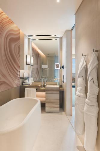 a bathroom with a white tub and a sink at Address Beach Resort in Dubai