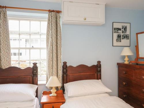 a bedroom with two beds and a window at 33 Island Street in Salcombe