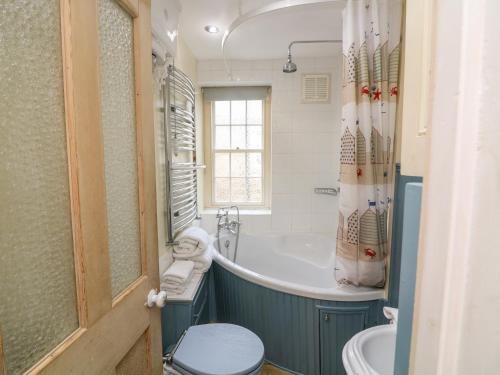a bathroom with a tub and a toilet and a sink at 33 Island Street in Salcombe