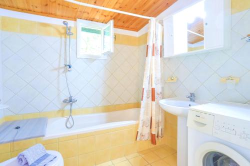 a bathroom with a tub and a sink at Villa Kefalaki in Katávolos