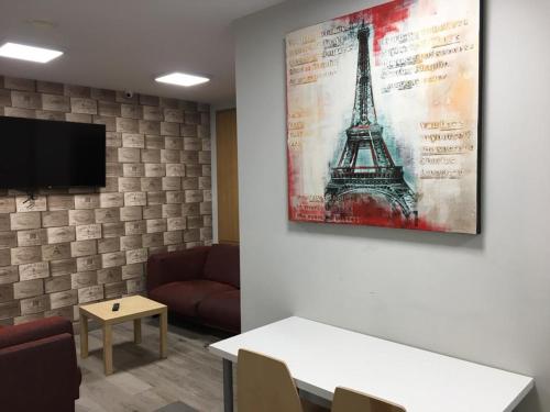 une chambre avec un canapé et une photo de la tour Eiffel dans l'établissement Albergue Logroño Centro, à Logroño