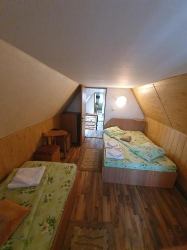 a attic room with two beds and a hallway at Casa Verde in Ranca