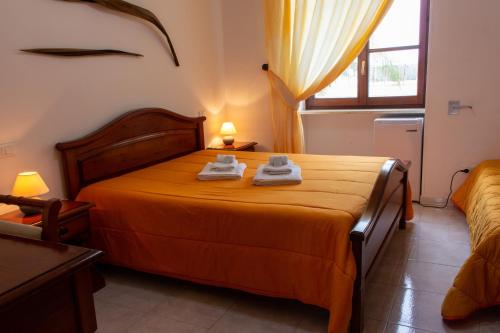 a bedroom with a bed with two towels on it at La Masseria Hotel Ristorante Centro Benessere in Cocumola