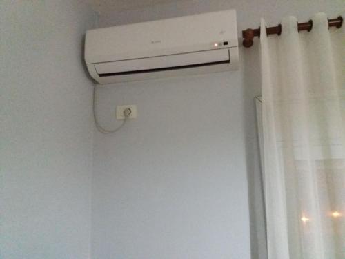 a air conditioner in a room with a curtain at CHEAP AND COMFORTABLE APARTMENT AT SEASIDE in Vlorë