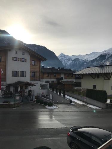 a car parked in a parking lot with mountains in the background at Elto Appartements in Kaprun