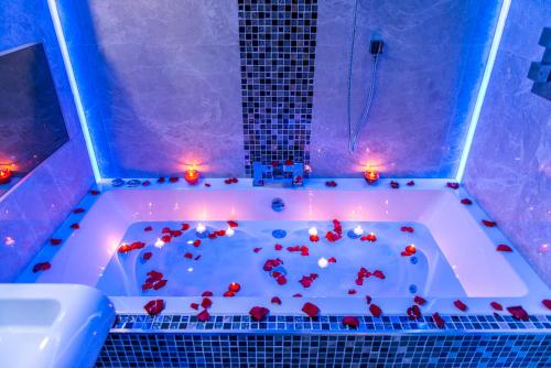 a bath tub filled with red hearts and candles at Aphrodite Suites Huddersfield in Huddersfield