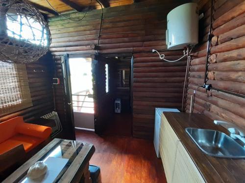 a bathroom with a sink in a log cabin at La Nubia Cabañas in Conlara