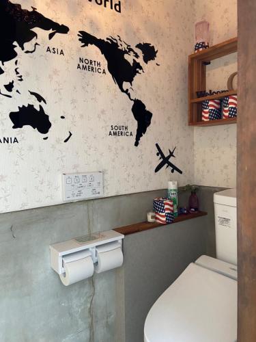 un bagno con una mappa del mondo sul muro di 古民家ゲストハウス穏 a Sakaide