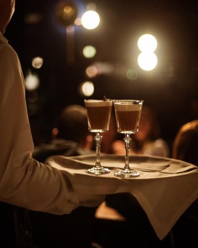 a waiter holding two glasses on a table at Gallery Hotel 4 Sup in Barcelona