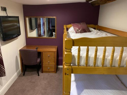 a bedroom with a bed and a desk and a mirror at Best Western Plus Sheffield Mosborough Hall Hotel in Sheffield