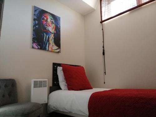 a bedroom with a bed and a painting on the wall at Appart-hôtel Chanzy / Angoulême in Angoulême