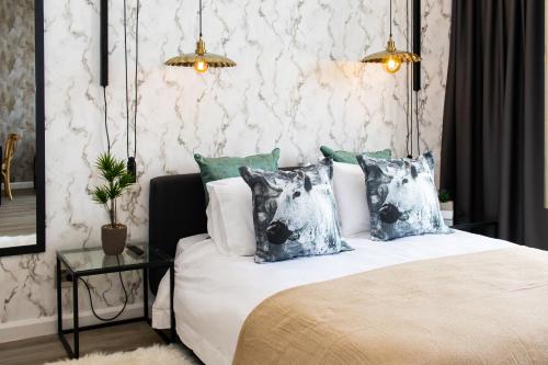 a bedroom with a bed with pillows and a table at Menlyn Marble Print Apartment in Pretoria