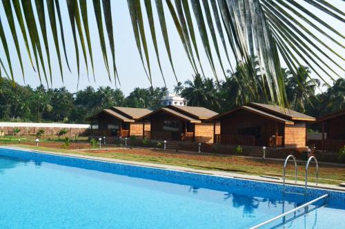 a house with a swimming pool in front of it at Radhika Eco Resort(Odonata) in Arambol