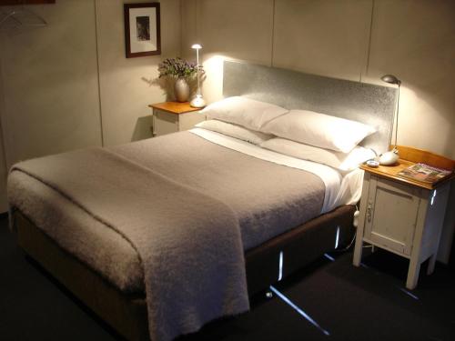 奧蘭治的住宿－黑羊住宿加早餐旅館，一间卧室配有一张大床和一个床头柜