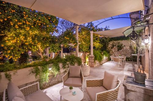 an outdoor patio with chairs and an umbrella at Heritage Villa Nobile in Dubrovnik