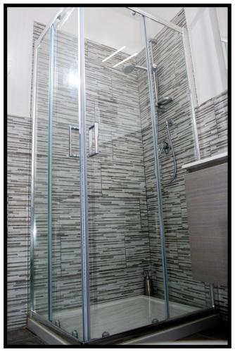 a shower with a glass door in a bathroom at Villa Bianca in Orosei