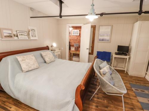 1 dormitorio con 1 cama y 1 silla en Horton Lodge Boathouse en Leek