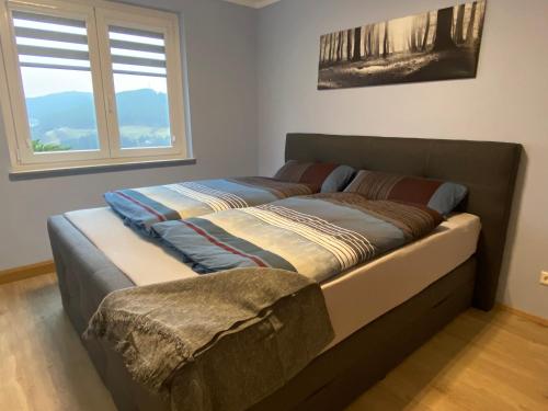 two beds in a room with two windows at Ferienwohnung am Hirschkopf in Baiersbronn