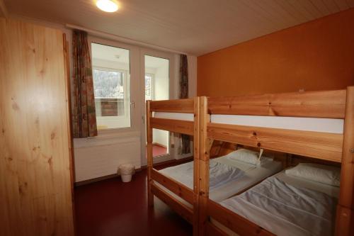 two bunk beds in a room with a window at juhui Arosa in Arosa