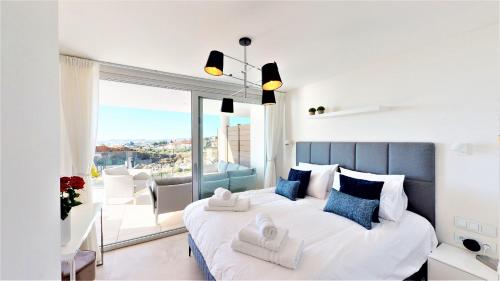 ein Schlafzimmer mit einem großen weißen Bett und einem Balkon in der Unterkunft Panoramica views superb luxury apartment in Fuengirola