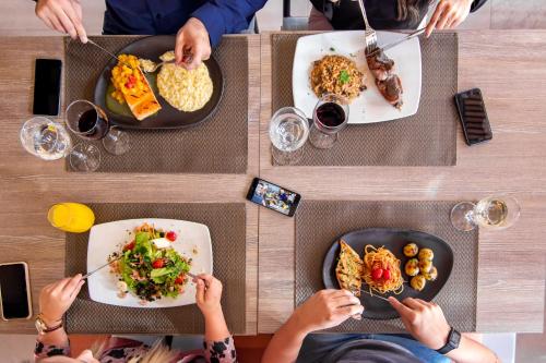 a group of people sitting at a table eating food at Novotel Criciuma in Criciúma