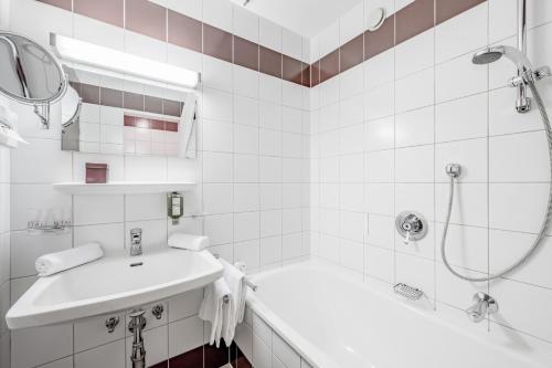 a white bathroom with a sink and a shower at Hotel Sportiv by VAYA in Obergurgl