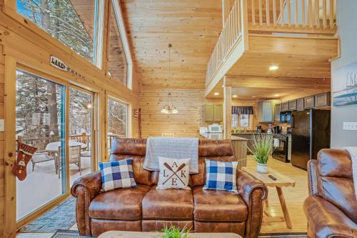 a living room with a couch and a kitchen at Contemporary ADK 5 Bedroom Chalet on Schroon in Schroon Lake