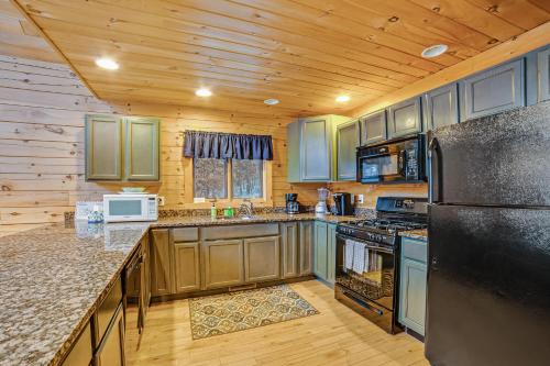 a kitchen with wooden cabinets and a black refrigerator at Contemporary ADK 5 Bedroom Chalet on Schroon in Schroon Lake