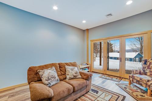 a living room with a couch and a window at Contemporary ADK 5 Bedroom Chalet on Schroon in Schroon Lake