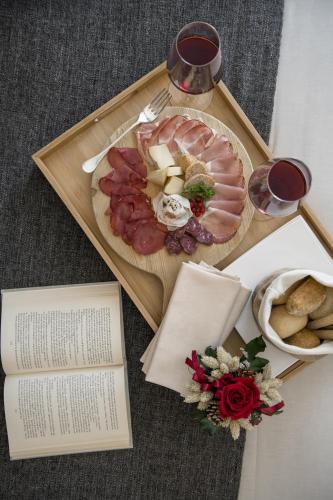 a plate of food with meat and cheese and a book at Miramonti Park Hotel in Bormio