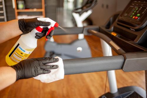 a person in black gloves holding a bottle of bleach at Novotel Criciuma in Criciúma