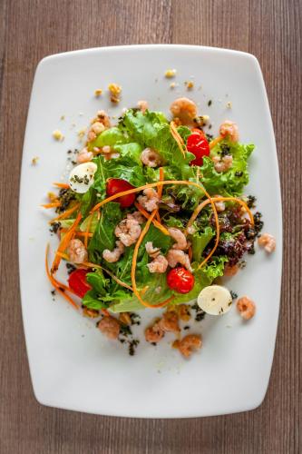 a white plate with a salad on a table at Novotel Criciuma in Criciúma