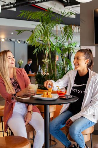 two women sitting at a table in a restaurant at Novotel Criciuma in Criciúma