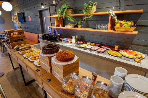 a buffet line with different types of food on display at Novotel Criciuma in Criciúma